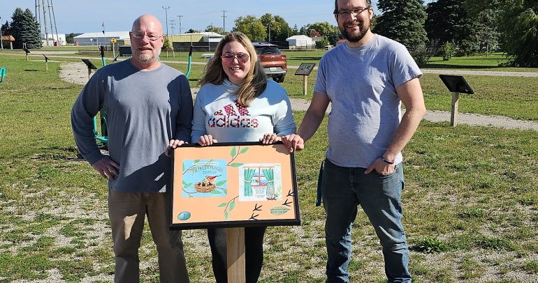 Staff in front of storywalk sign